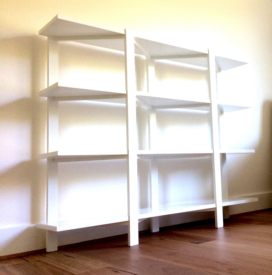 Large white lacquered bookshelf unit — three bays, five shelves